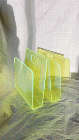 A video of someone placing a vinyl record in a green lucite magazine holder